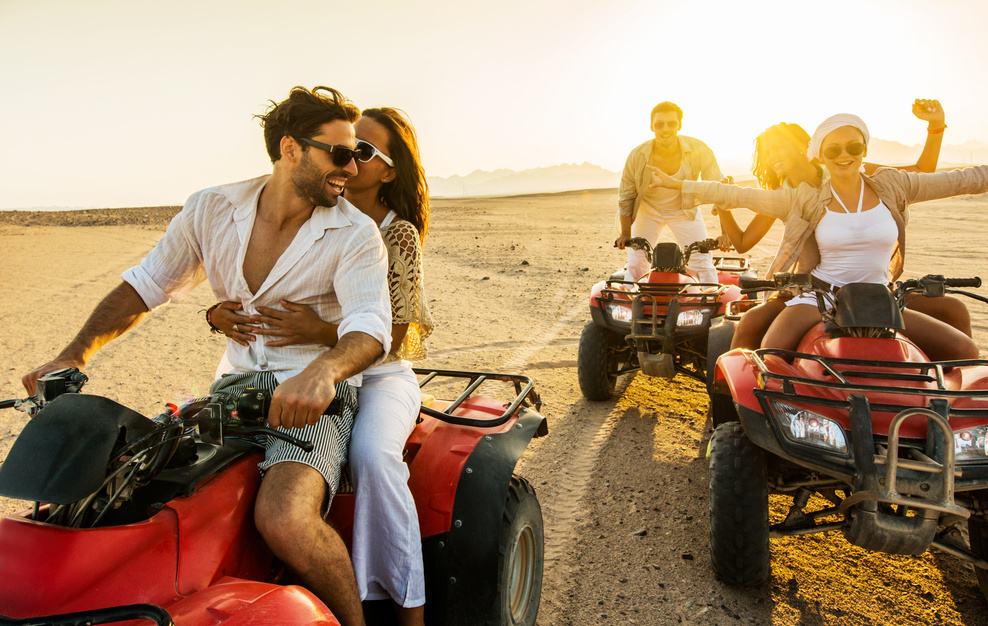 Having fun on quad bikes at sunset.